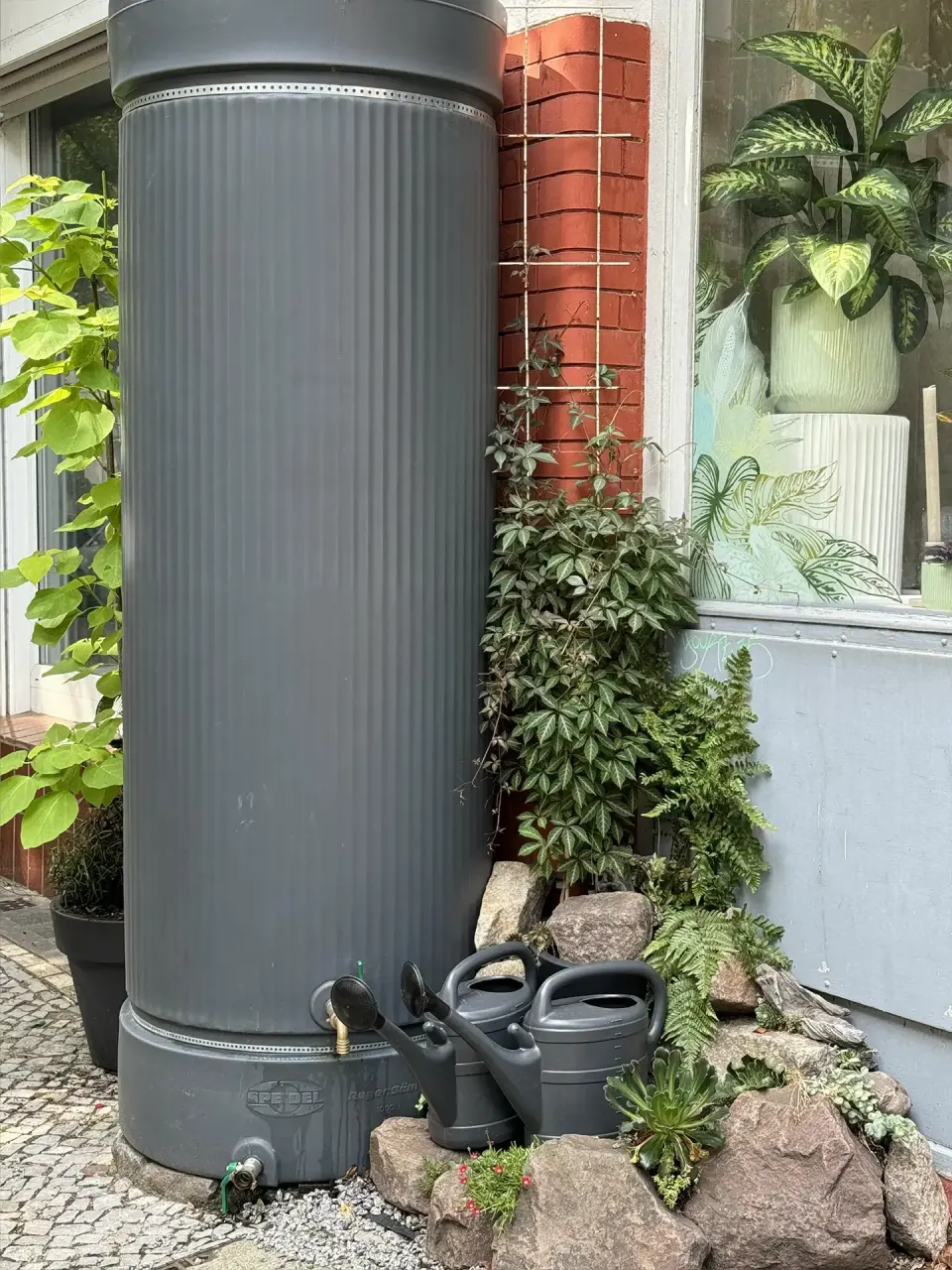 Grünfläche mit Bäumen an einem Wasserlauf in der Stadt